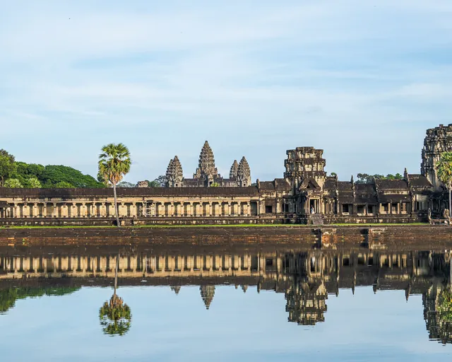 Angkor Wat spiegelt sich im Wasser unter blauem Himmel