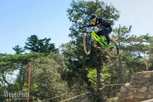 Downhill-Biker im Sprung durch einen Pinienwald auf Lošinj