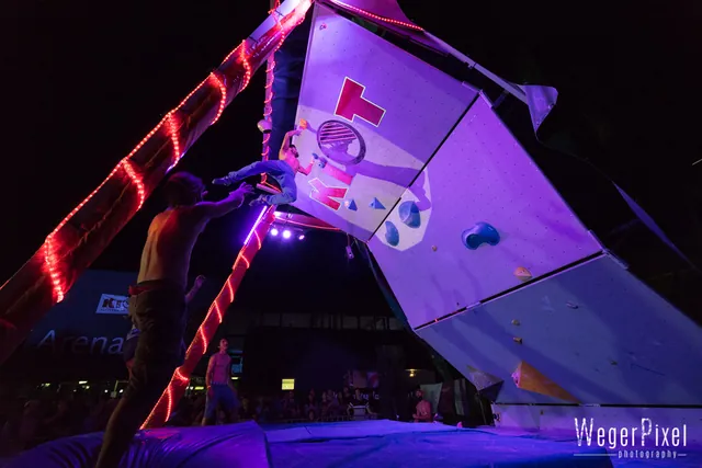 Kletterer am KIOT Bouldercup in Lienz unter violettem Scheinwerferlicht
