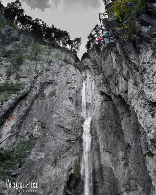 Kletterer hoch oben in der Felswand neben dem Wasserfall Frauenbach in Lavant