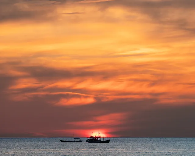 Sonnenuntergang über dem Meer bei Koh Rong mit Booten am Horizont
