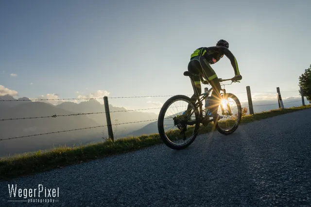 Silhouette eines Mountainbikers im Gegenlicht der tiefstehenden Sonne